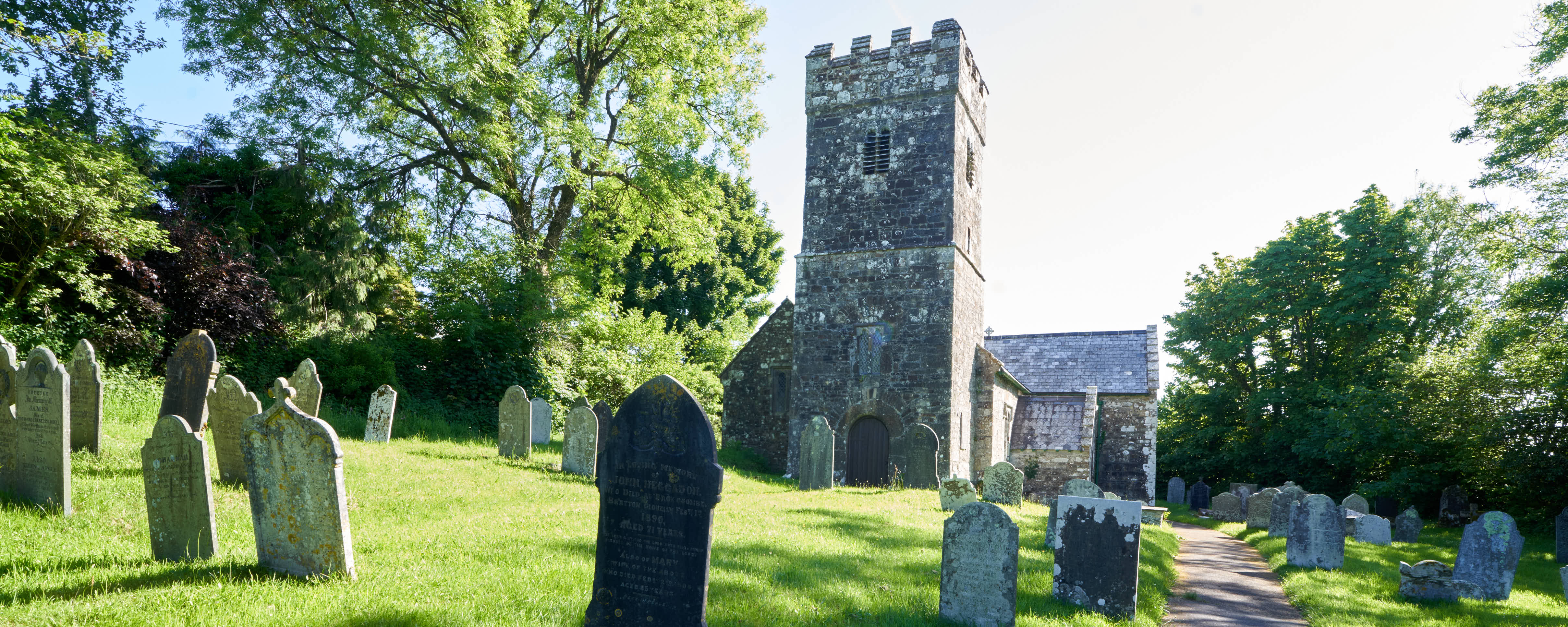 An old Norman church tower in a small grave yard